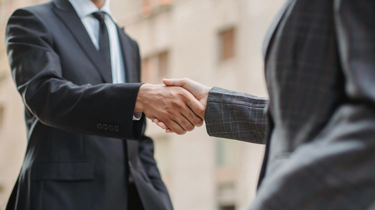Zwei Personen geben sich die Hand und haben über Leadinfo den Vertrag schneller abgeschlossen.